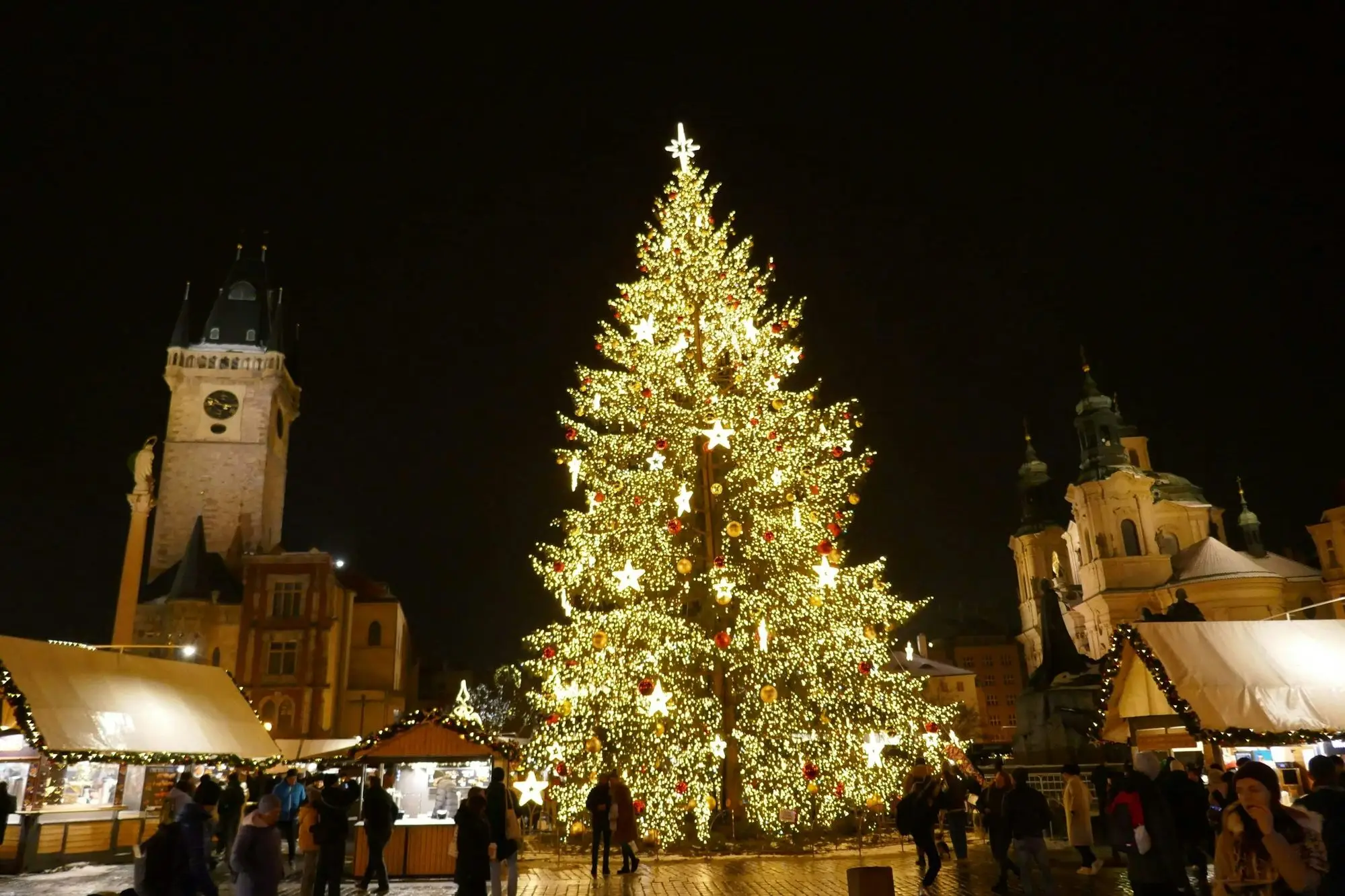 A large lit Christmas tree at the Christmas market in Prague at night